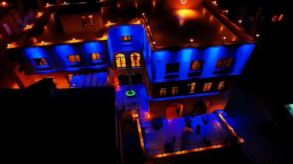 une maison avec des lumières bleues allumées la nuit dans l'établissement Tuğhan Hotel, à Mardin