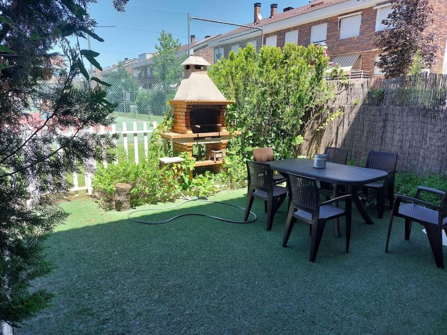 un patio trasero con mesa, sillas y cenador en Chalet urbano en Salamanca, en Santa Marta de Tormes