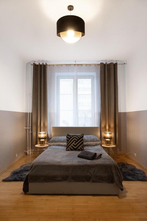 sypialnia z dużym łóżkiem i oknem w obiekcie ClickTheFlat Aleje Niepodległości Center Apart Rooms w Warszawie