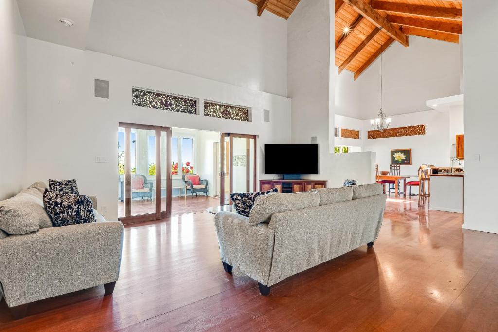 sala de estar con 2 sofás y TV de pantalla plana en The Aloha Villa - 30-Night Minimum, en Honokaa