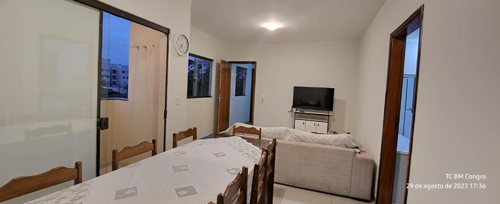 ein Esszimmer mit einem Tisch und einem Sofa in der Unterkunft DOURADOS GUEST FLAT PEDRA BONITA in Dourados