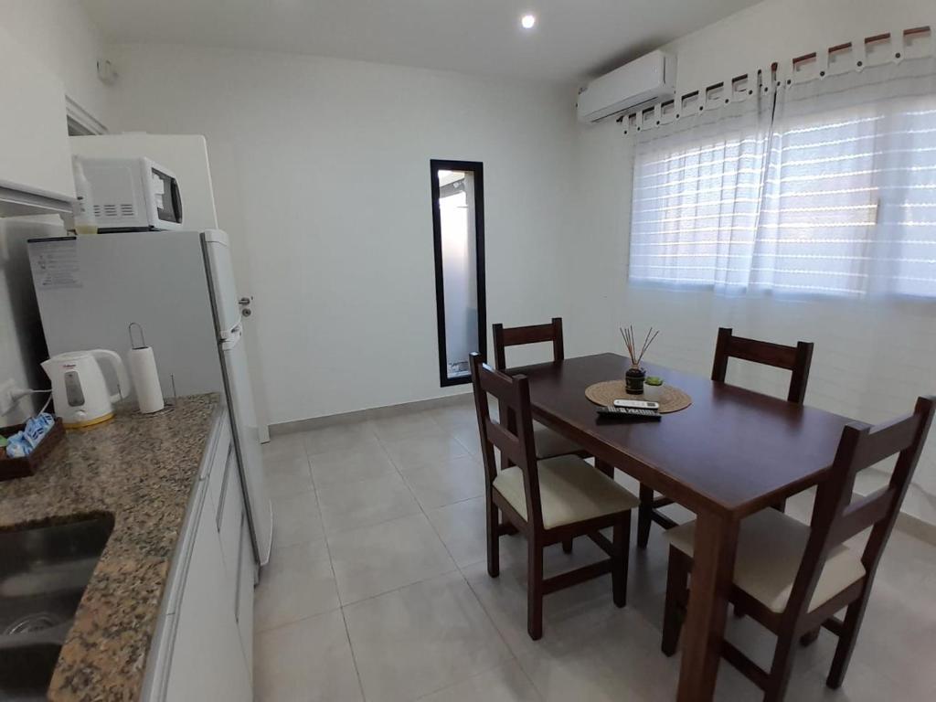 a kitchen with a table and chairs and a refrigerator at TresA -1- in Tres Arroyos