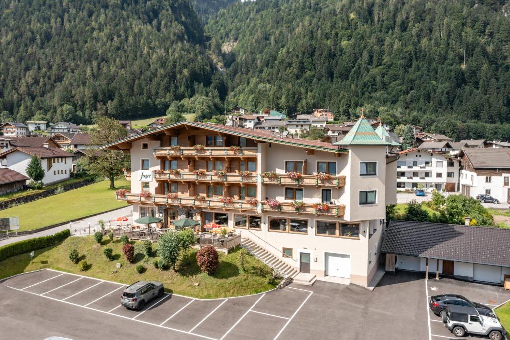 an aerial view of a hotel with a parking lot at Hotel Gasthof Jäger Zillertal in Schlitters