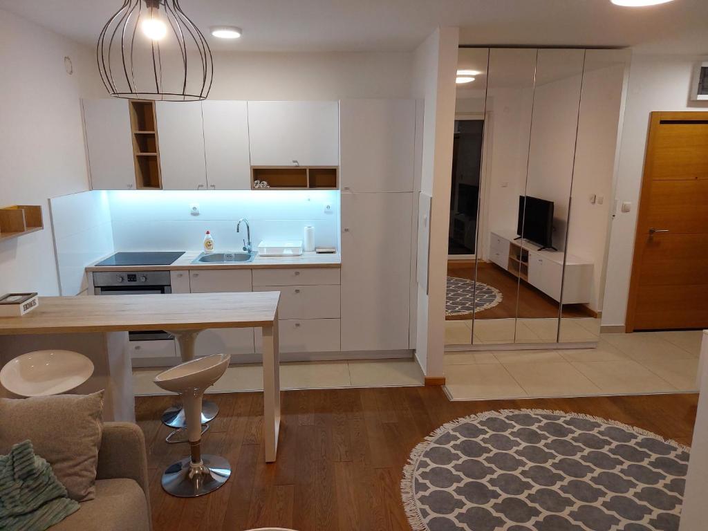 eine Küche und ein Wohnzimmer mit einem Tisch und einem Sofa in der Unterkunft Mila Apartment sajam in Novi Sad