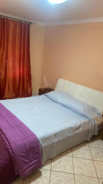 a large bed in a room with a window at Casy&Angy in Braşov