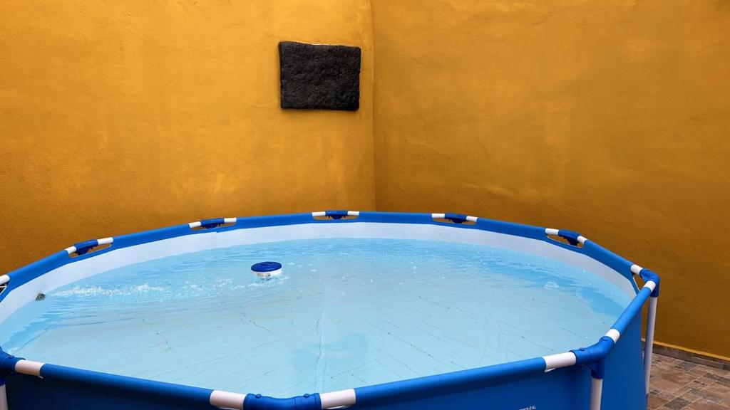 uma grande piscina num quarto com uma parede amarela em Tradicional Casa Canaria con piscina y vistas al Teide em Icod de los Vinos