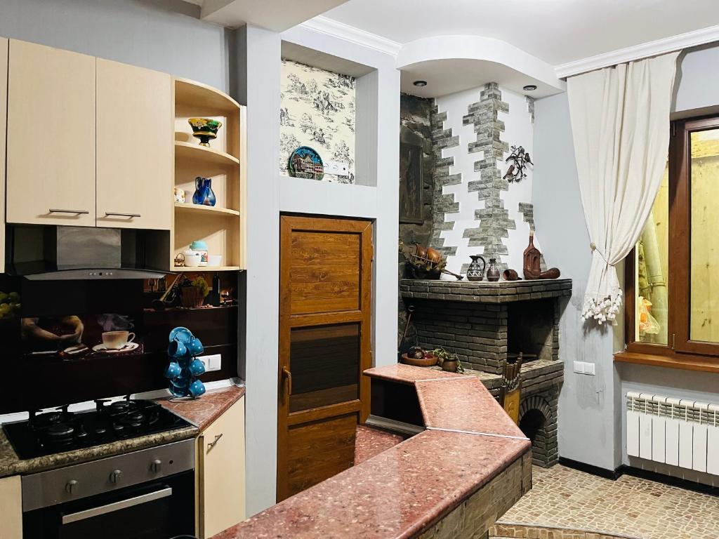 a kitchen with a stove top oven next to a fireplace at Jeji's apartment in Tbilisi City
