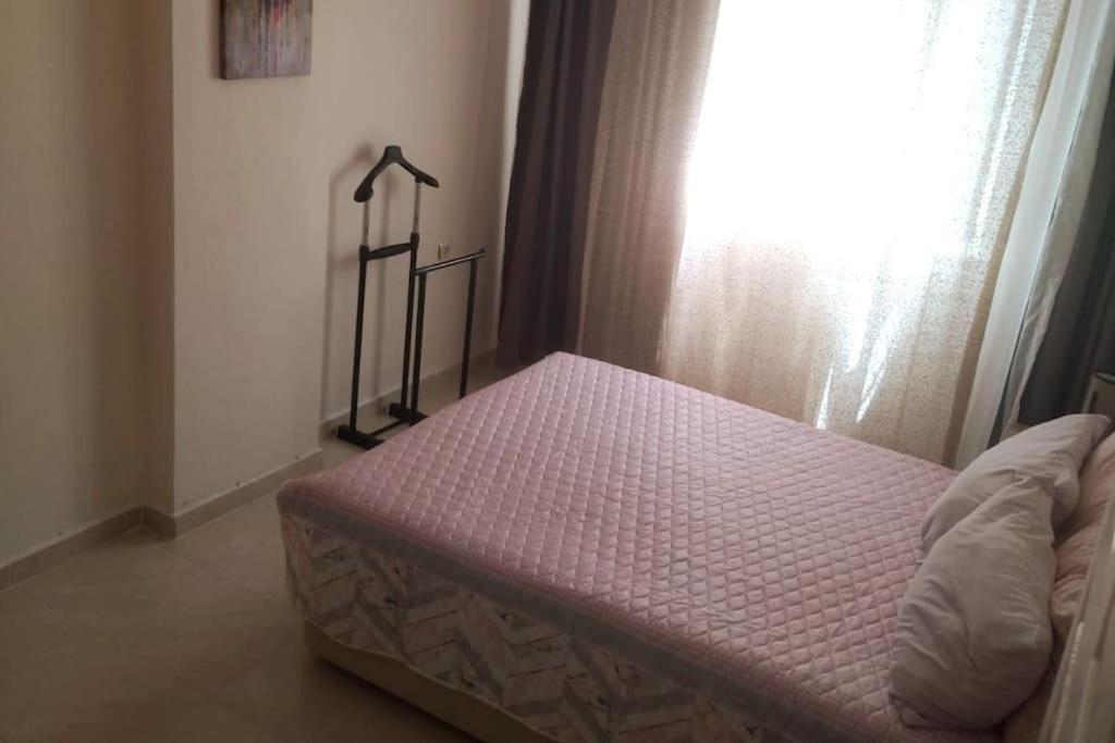 een bed in een slaapkamer naast een raam bij Светлая квартира с отдельной кухней и ванной 1+1 in Didim