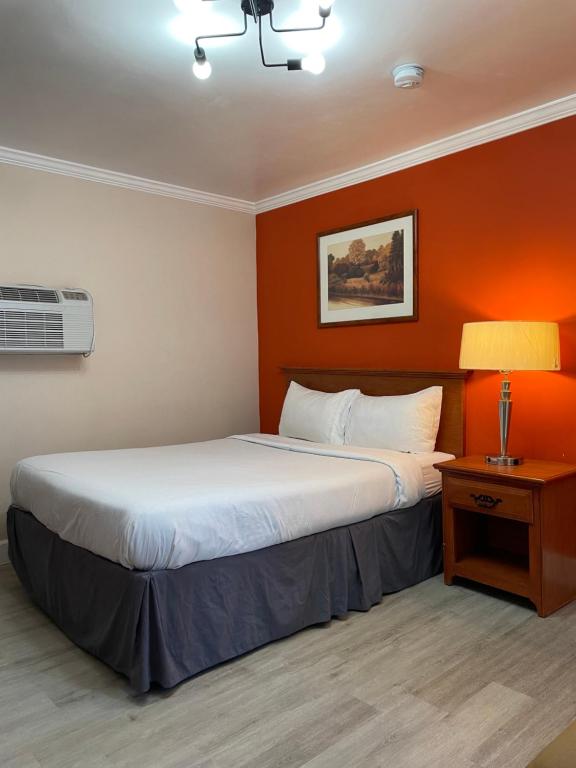 a hotel room with a large bed and a lamp at Howard Johnson by Wyndham Ridgecrest, CA in Ridgecrest