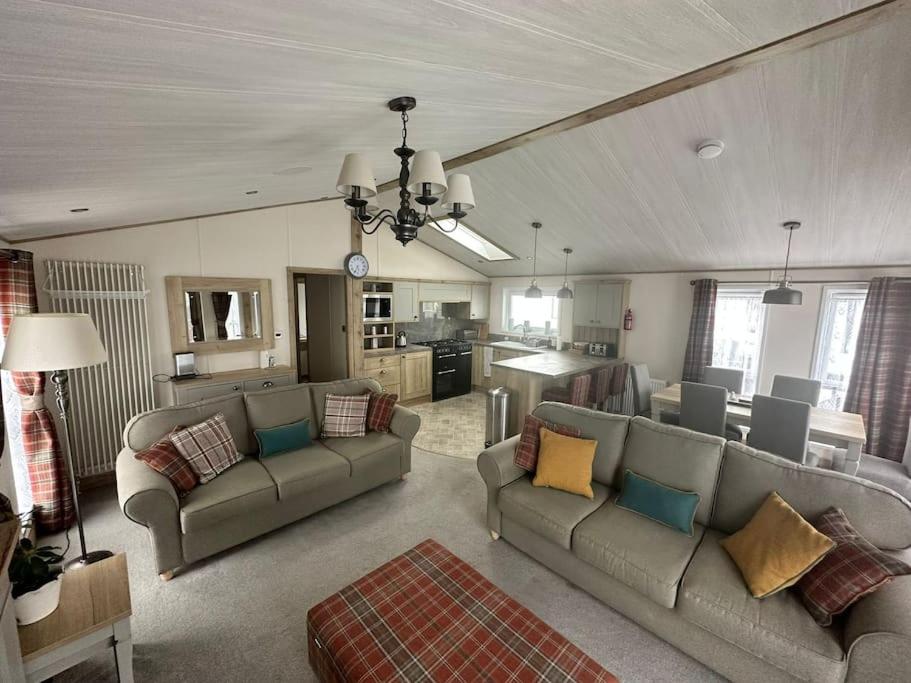sala de estar amplia con sofás y cocina en Luxury 6-8 Berth Lodge en New Milton