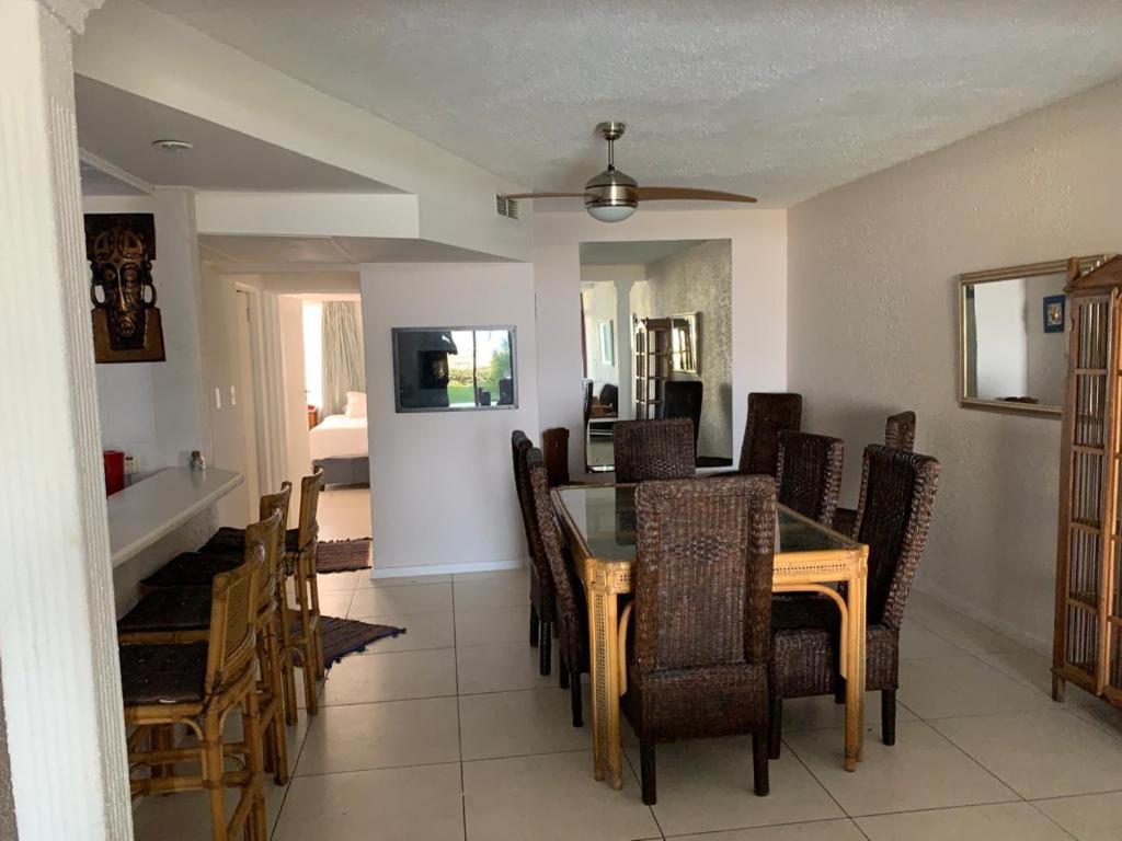 a dining room and living room with a table and chairs at C8 Surfside in Durban