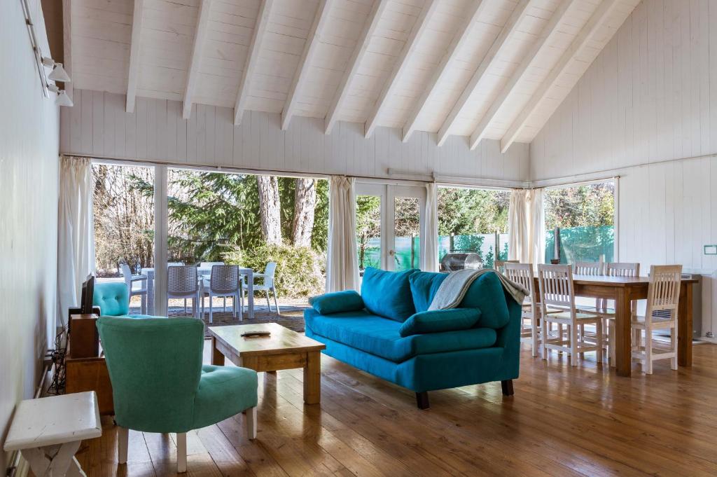 ein Wohnzimmer mit einem blauen Sofa und Stühlen in der Unterkunft BOG El Granero in Villa La Angostura