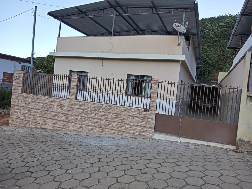 ein Gebäude mit einem Zaun davor in der Unterkunft CASA DA LÉIA in Caparaó Velho
