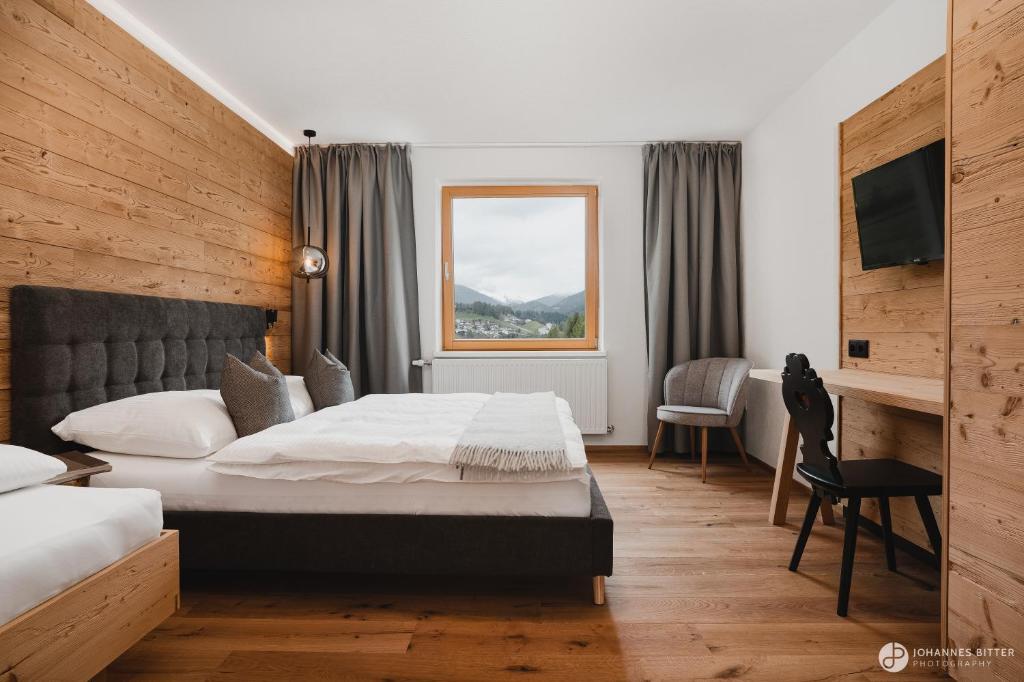 um quarto de hotel com uma cama e uma secretária em Stoacherhof Apartments em Matrei am Brenner