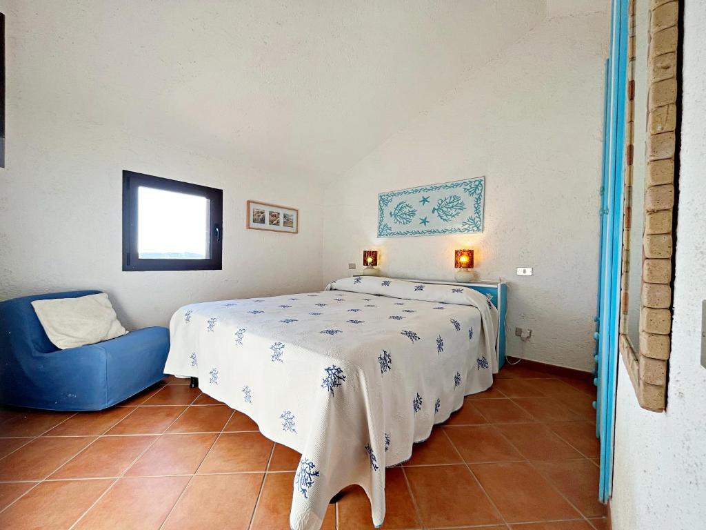 una camera con letto e sedia blu di DomoMea - Le Ginestre a Porto Istana