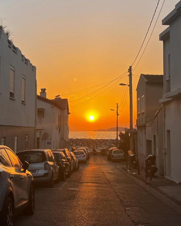 une rue avec des voitures garées dans une rue où vous pourrez admirer le coucher du soleil dans l'établissement Authentique T3 calme entre mer et Calanques, à Marseille