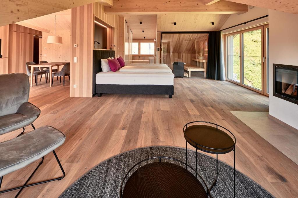 ein Schlafzimmer mit einem Bett und ein Wohnzimmer in der Unterkunft Staufen Chalets am Schlossberg in Oberstaufen