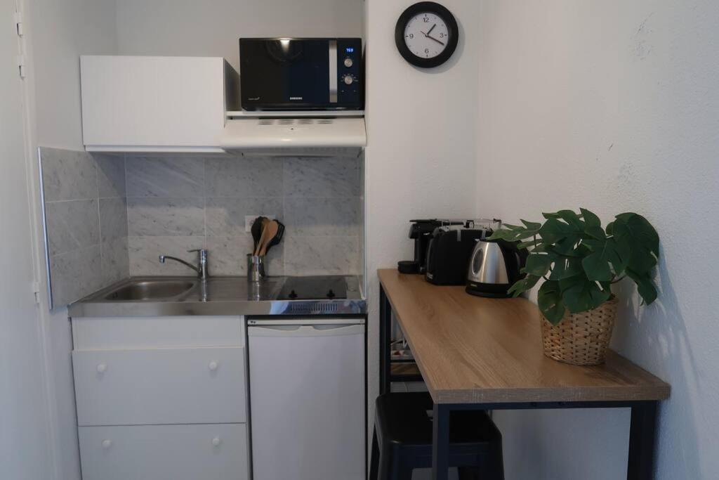 a kitchen with a sink and a clock on the wall at Studio Gare, Europole in Grenoble