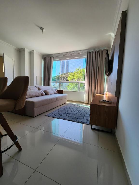 a living room with a couch and a window at Apartamento Balneário Camboriú in Balneário Camboriú