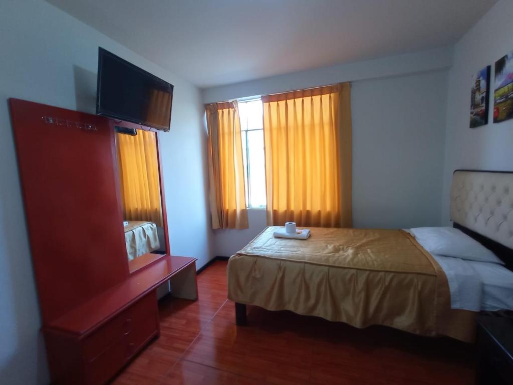 a bedroom with a bed and a dresser and windows at hospedaje kayros in Arequipa