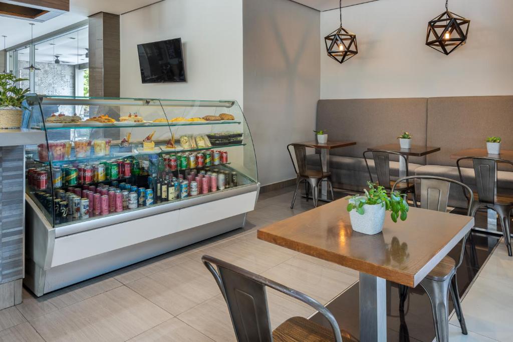 a restaurant with a display case filled with drinks at Crowne Plaza Airport by IHG in Tocumen