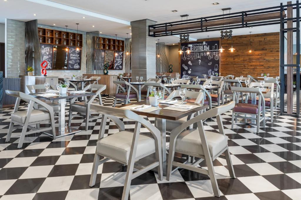a restaurant with tables and chairs on a checkered floor at Crowne Plaza Airport by IHG in Tocumen