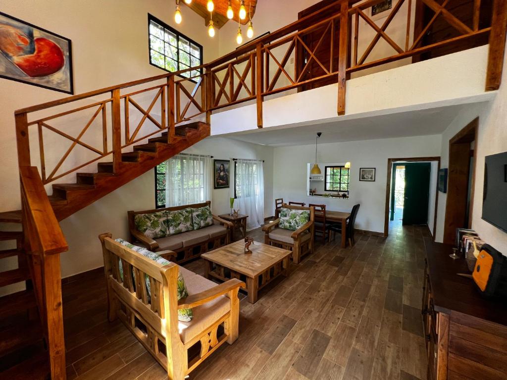 a living room with a wooden floor and a staircase at Villa unter Palmen in Jarabacoa