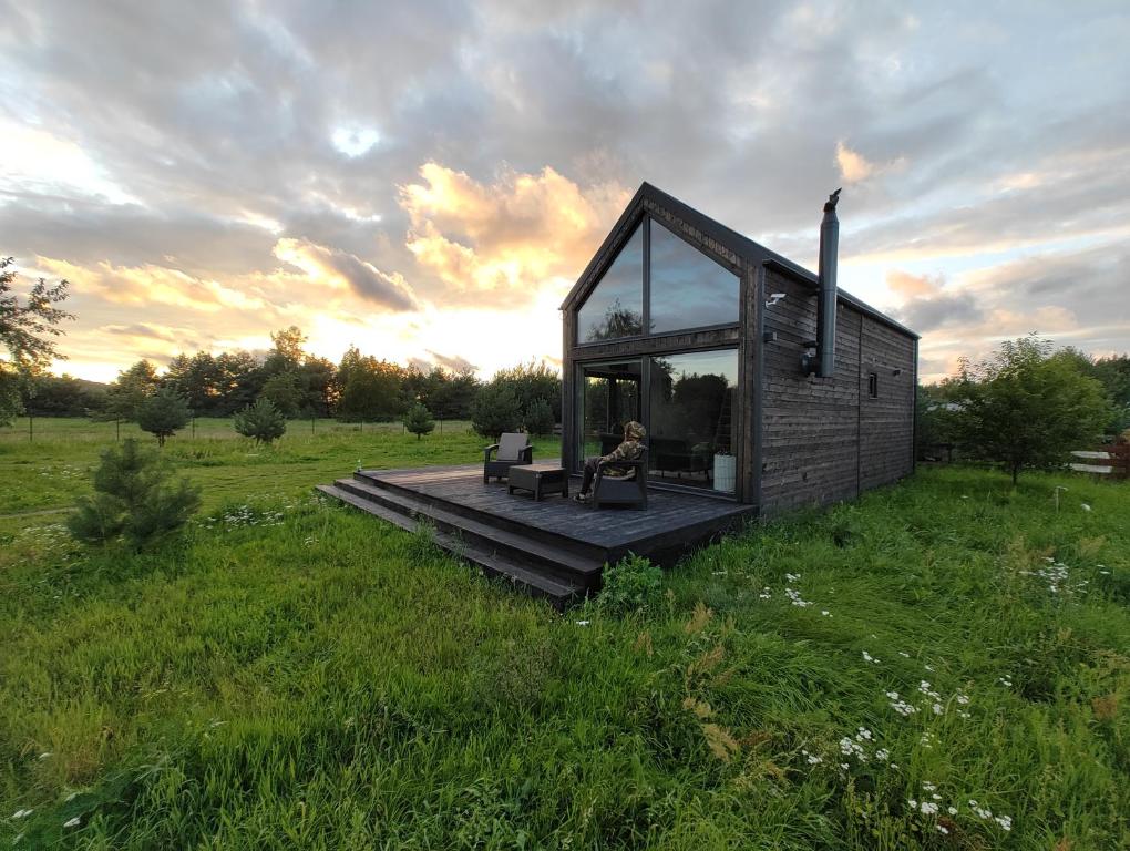 a small house with a deck in a field at Your Private Hytte in Smołdzino