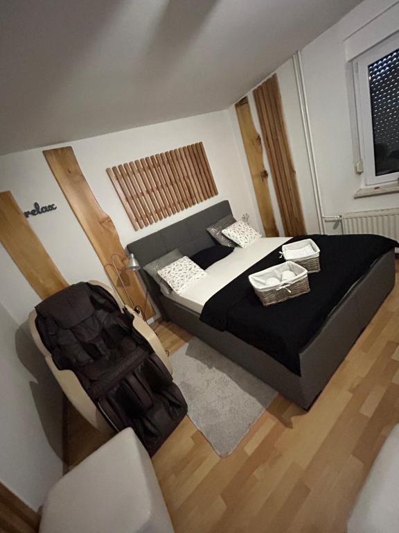 ein kleines Schlafzimmer mit einem Bett und einem Stuhl in der Unterkunft Apartments and Wellness Ščavničar in Ljutomer