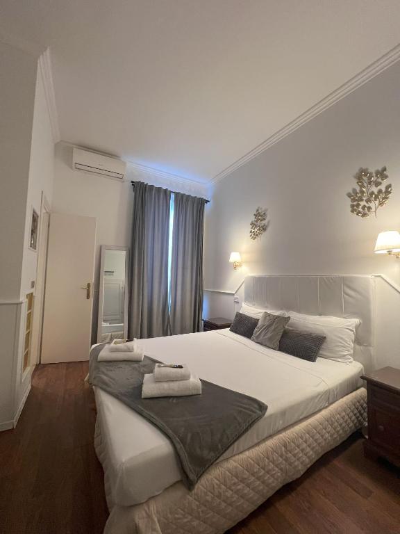 1 dormitorio con 1 cama blanca grande y toallas. en Suitedream Vatican, en Roma