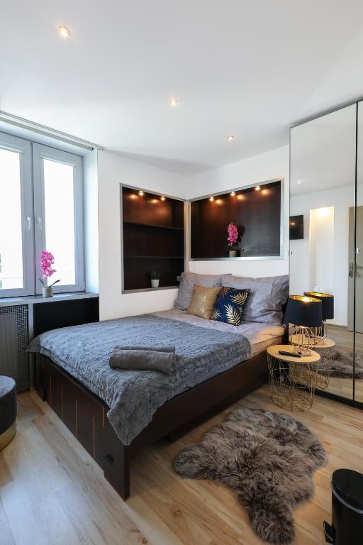 1 dormitorio con 1 cama grande en una habitación con ventanas en ClickTheFlat Chłodna Center Apart Rooms, en Varsovia