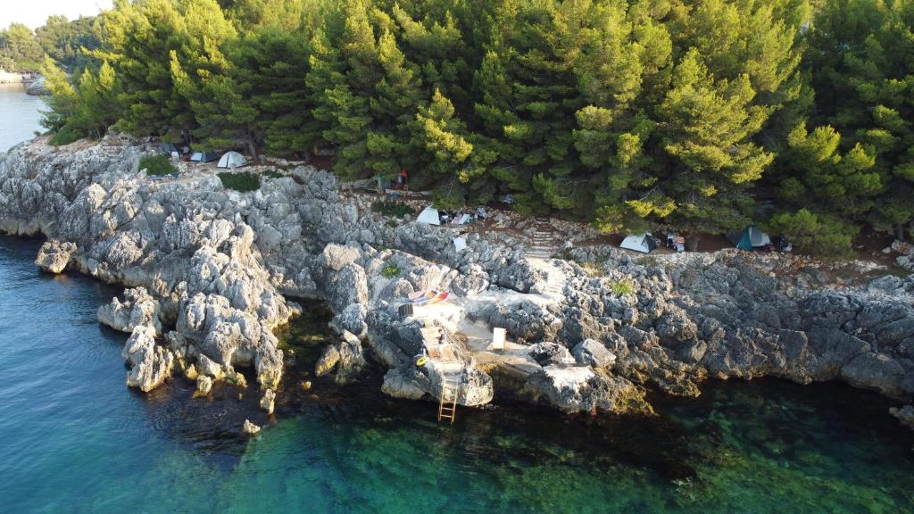 une vue aérienne sur une île rocheuse dans l'eau dans l'établissement Pine Side Camp, à Himarë