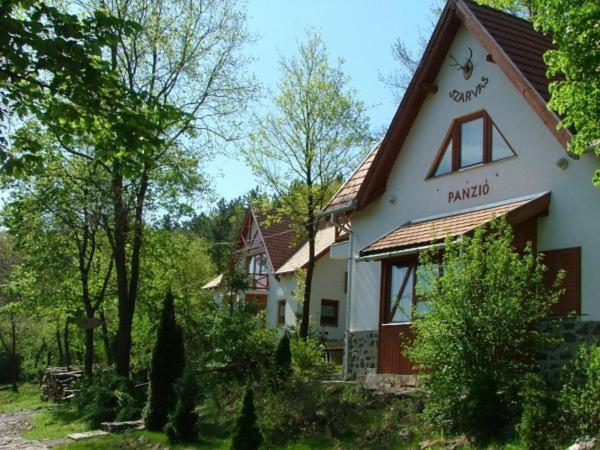 ein großes weißes Haus mit rotem Dach in der Unterkunft Szarvas Panzió in Erdőbénye