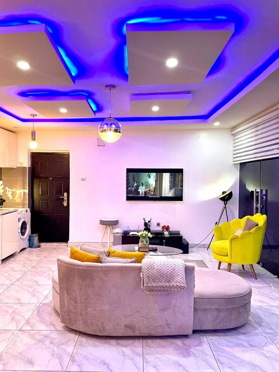 a living room with a couch and yellow chairs at THE GILPINs in Lekki