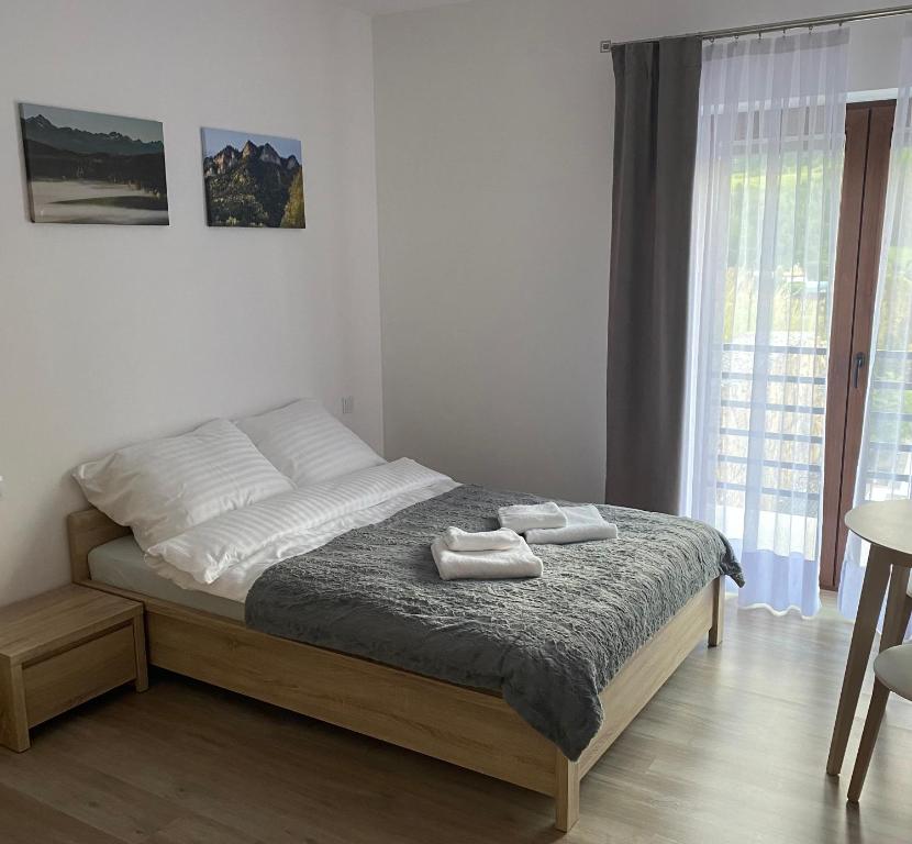 W Pieninach pokoje في سروموس وايزين: غرفة نوم عليها سرير وفوط