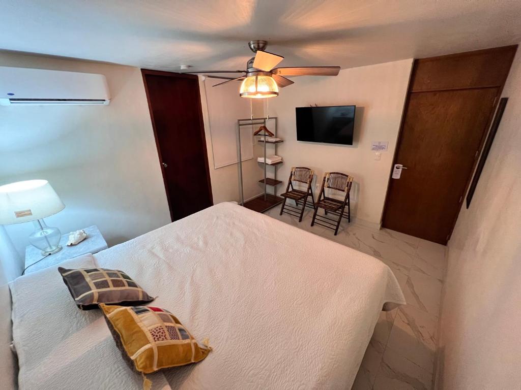 a bedroom with a bed and a flat screen tv at Hosteleria Casa Margarita in Mazatlán