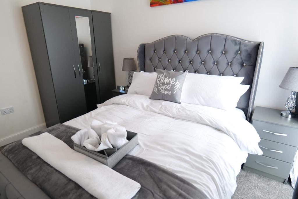 a bedroom with a large white bed with a silver headboard at Milton Keynes Love Home in Bletchley