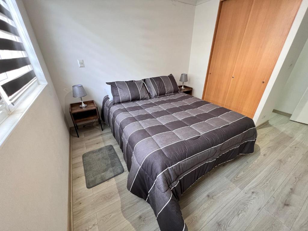 een slaapkamer met een bed en een houten deur bij Comoda Estadia en Talcahuano in Talcahuano