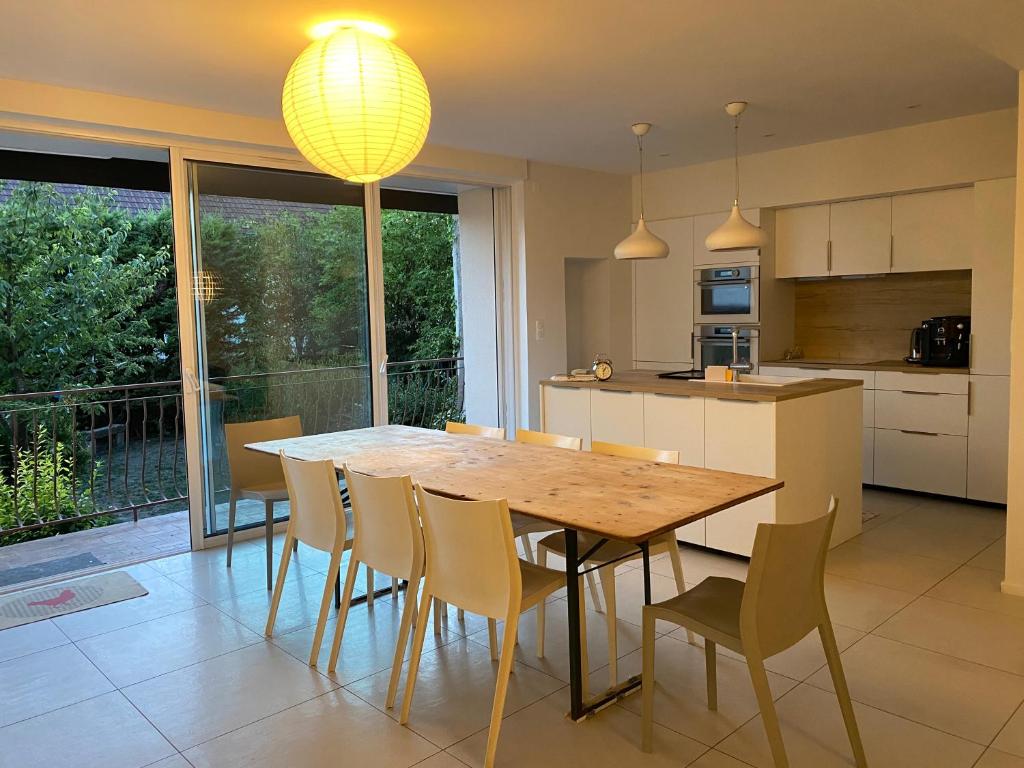 een keuken en eetkamer met een houten tafel en stoelen bij La maison Familiale in Dijon