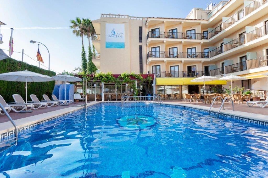 a large swimming pool in front of a hotel at Hotel Amoros in Cala Ratjada