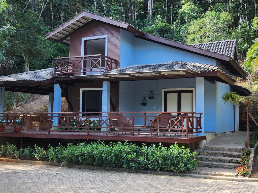 uma casa azul com um alpendre e cadeiras em Casa do Luiz Antônio em Pacoti