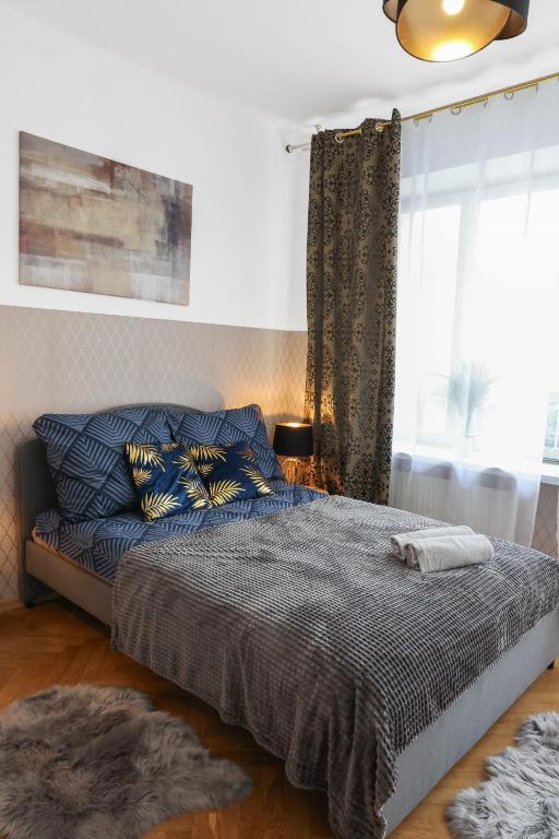 een slaapkamer met een bed en een raam bij ClickTheFlat Three Crosses Square Apart Rooms in Warschau
