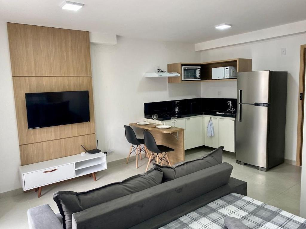 a living room with a couch and a kitchen at AP1422 ar condicionado piscina academia coworking etc in Juiz de Fora
