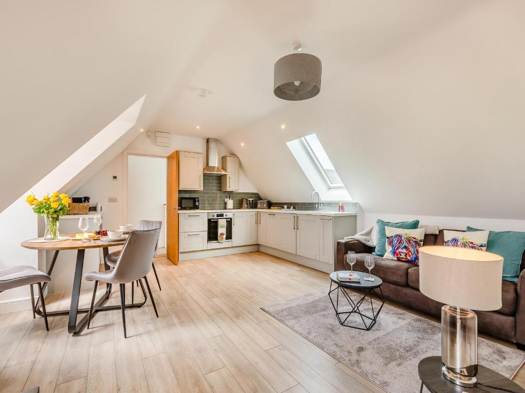 a living room and kitchen with a couch and a table at Woodlands Annexe in West Pennard