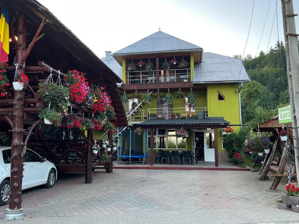 żółty budynek z samochodem zaparkowanym przed nim w obiekcie Pensiunea Gaiu w Albacu
