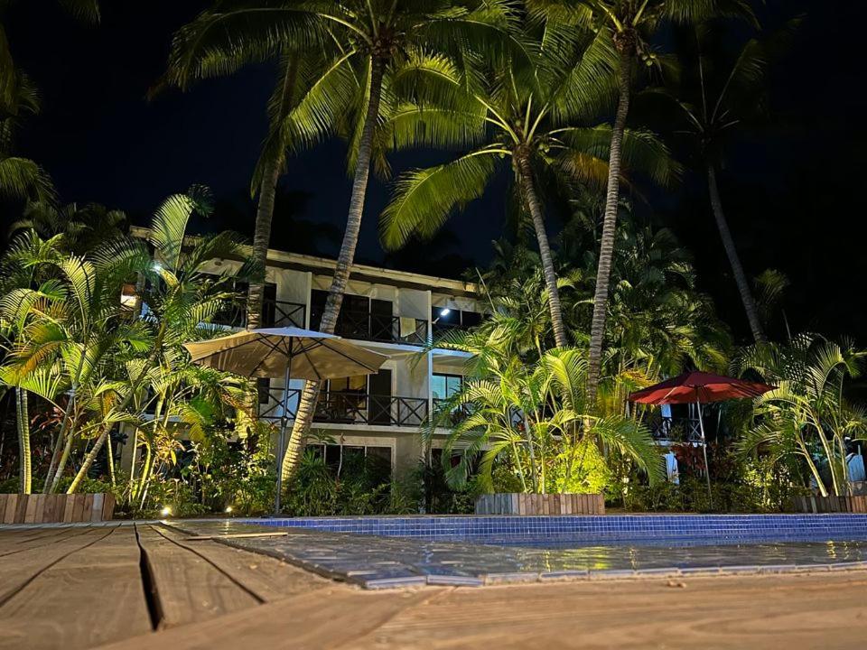 a building with palm trees in front of a resort at Oasis Palms Hotel in Nadi