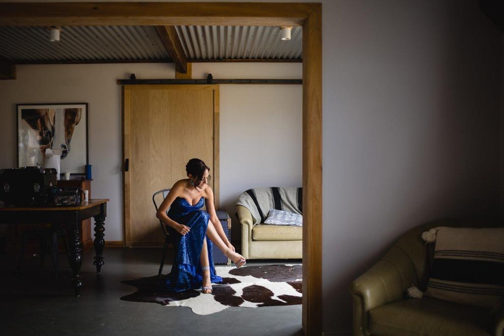 a woman in a blue dress standing in a room at Margaret River Retreat in Forest Grove