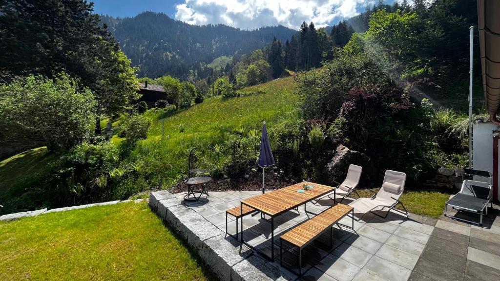 a patio with a table and chairs and a view of a mountain at Chalet im Gus - Flumserberge & Walensee in Oberterzen