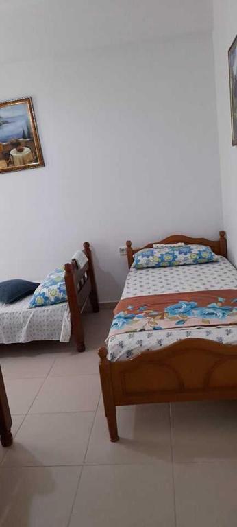 1 dormitorio con 2 camas y una foto en la pared en Sanos GardenApartament, en Sarandë