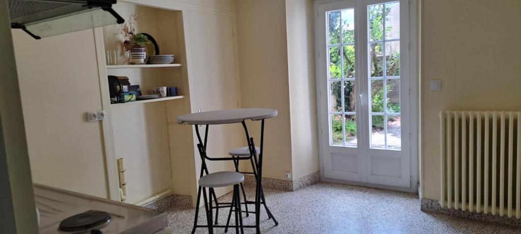 a kitchen with two stools in a room with a door at Super Appartement in La Souterraine